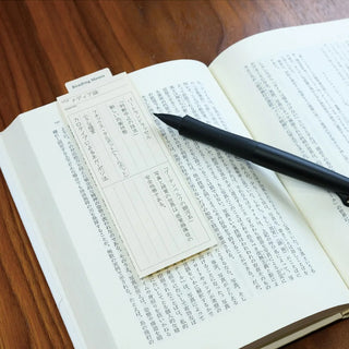 Reading memo tabs in an open book with a black pen across the pages