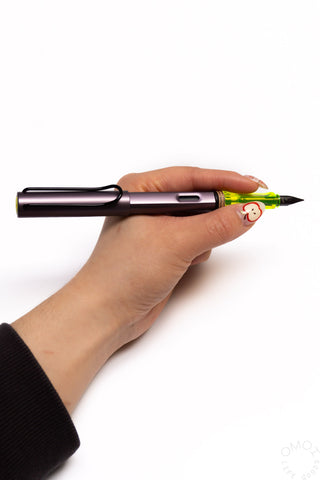 LAMY AL-Star fountain pen, aubergine body with fine nib, held in hand