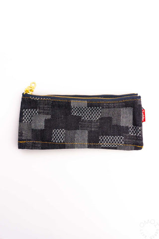 Geometric patchwork pen pouch with gold zipper, dark grid pattern
