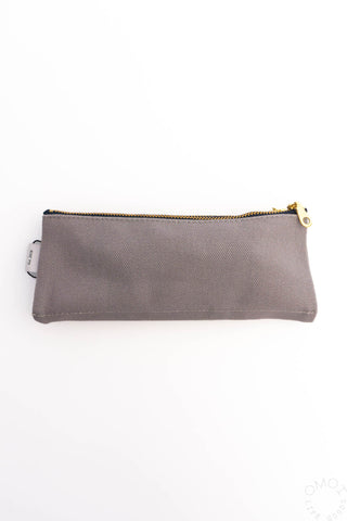 Dark grey zip pencil pouch with gold zipper hardware and fabric front