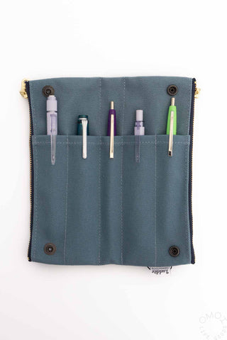 Blue grey bendy pen case with pen slots and snap buttons, shown closed