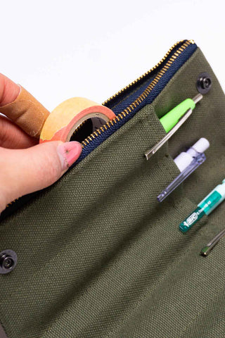 Khaki bendy pen case close-up: zipper edge with pens in elastic loops
