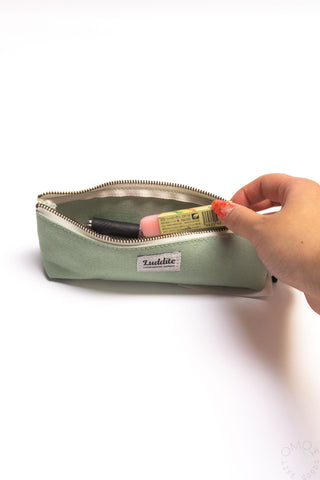 Sage LUDDITE canvas boat pen case with gold zipper, holding pens inside.