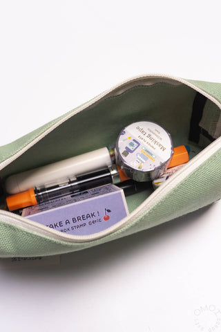 Open sage-green box pen case holding pens and small stationery items