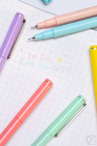 Pastel gel pens on grid paper, close-up of colored pen tips and barrels