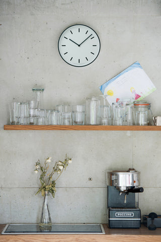 Small wall clock with white dial and black frame, with black hands