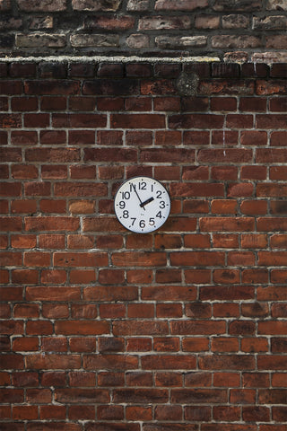 Round aluminum wall clock, white dial with black numerals and hour/minute hands.