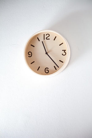 Natural wood wall clock with cream dial, black markers and three hands