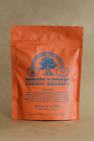 Orange bath soak pouch with blue forest emblem and FOREST BATHING text