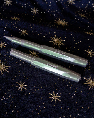 Two Kaweco Lunar Sport rollerball pens in shadow green with gold-toned details