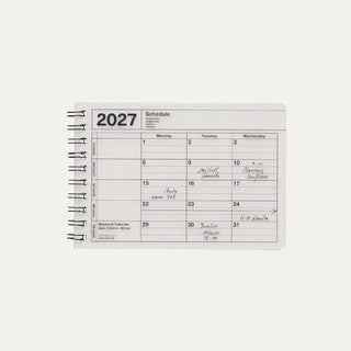 Ivory 2027 notebook calendar cover showing a weekly schedule page and spiral rings
