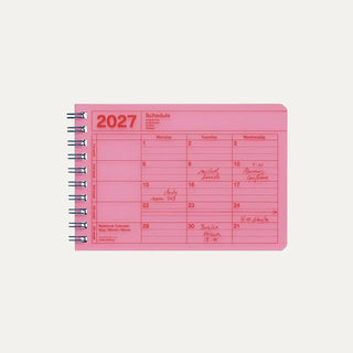 Pink 2027 notebook calendar cover showing a weekly schedule page and spiral rings