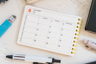 2027 June monthly calendar page in small notebook with gold spiral rings