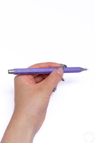 Purple gel ink metal pen held in hand with visible cap and tip