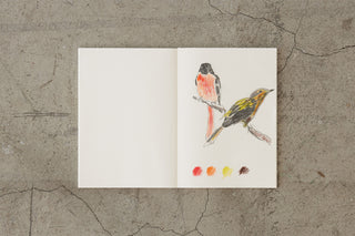 Open white cotton notebook with bird illustration on right page
