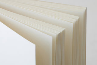 Side view of white cotton notebook showing thick page block