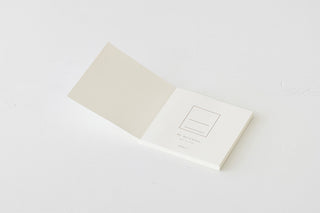 White cotton notebook open view with blank label page and inner paper