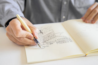 Hand writing with cream fountain pen in an open notebook
