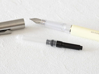 MD fountain pen converter with clear barrel and black end on white background
