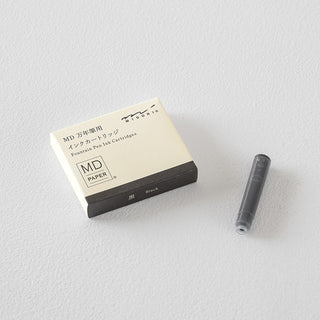 Fountain pen ink cartridge refill box with one cartridge beside it