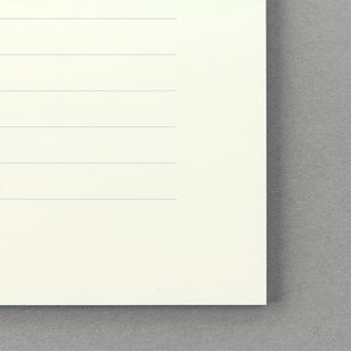 Close-up of cream lined letter paper corner with horizontal lines