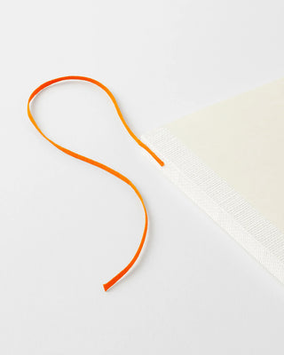 MD notebook with orange cord tie and textured cream cover corner
