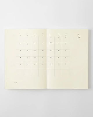 MD notebook calendar spread with date grid and small day numbers, cream paper