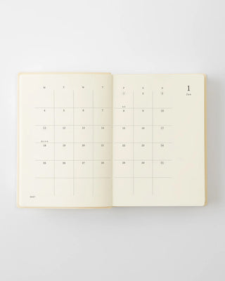 Open planner calendar spread with daily date blocks