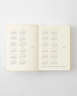 Open page-a-day planner showing monthly calendar grid spreads