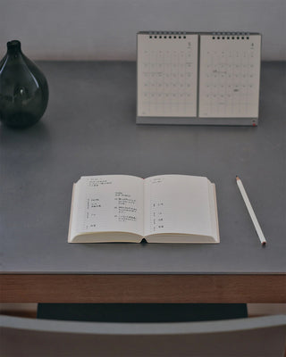Open page-a-day planner on tabletop with day pages and handwritten text
