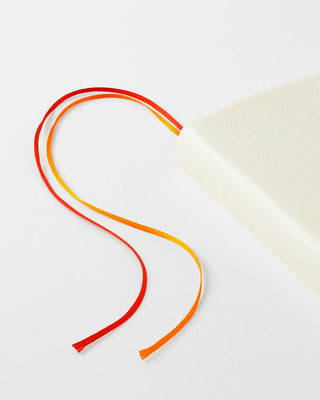 Cream page-a-day planner with red and orange ribbon ties