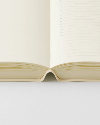 Opened page-a-day planner notebook showing spine and lined inner pages