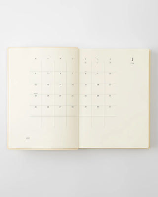 Open page-a-day planner notebook with numbered monthly date grid