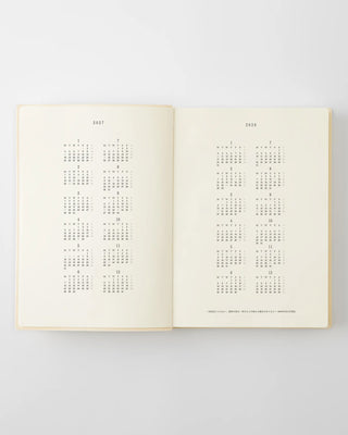 Open page-a-day planner notebook showing two month calendar grids