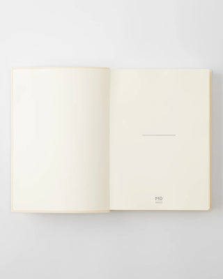 Open white page-a-day planner notebook with blank pages and small MD mark