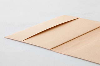 Beige hard-cover notebook with cover folded open, inner pages visible