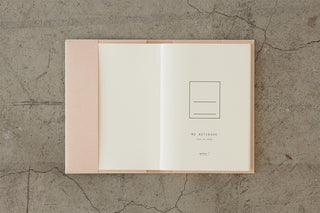 Opened beige A5 notebook with blank pages and a pocket inside cover