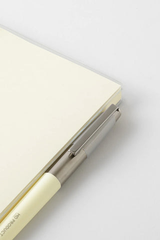 Cream A5 journal with metal pen inside a holder along the cover edge