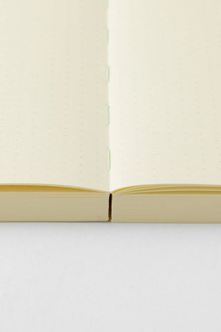 Opened cream A5 page-a-day journal with stitched binding and dotted pages
