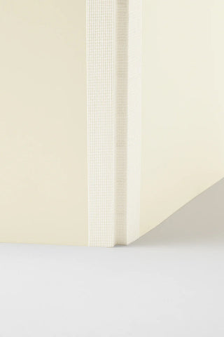 Cream dot grid notebook end view with vertical spine panel