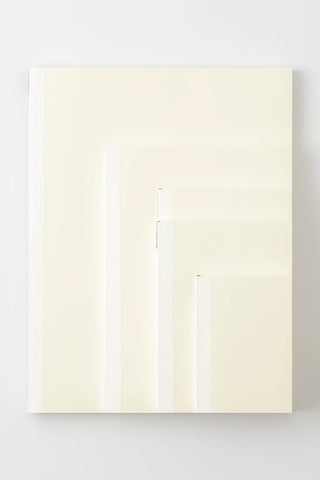 Open dot grid notebook with layered pages and blank cream sheets