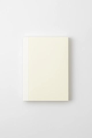 Cream dot grid notebook front cover with minimal design and binding edge