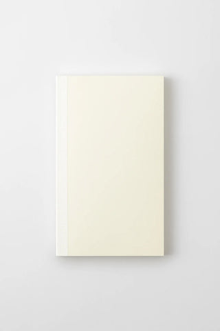 Cream notebook, closed with visible spine edge and clean front cover.
