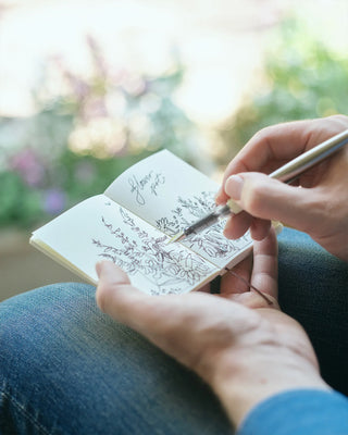 Blank sketch notebook with handwritten drawing on cream pages, open in use