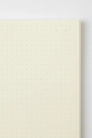 Close-up of cream dot grid pages with small green dot markers