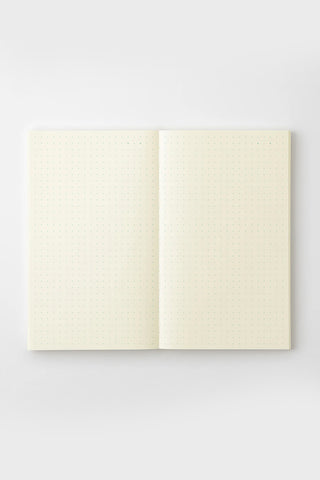 Cream dot grid notebook opened, showing two inner pages with dotted grid