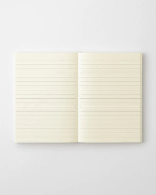 Lined notebook open with cream pages and evenly spaced horizontal ruled lines.