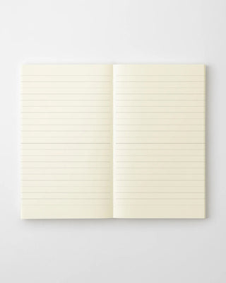 Lined notebook open, close view of cream pages with horizontal ruled lines.
