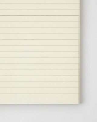 Lined notebook with light cream pages and horizontal ruled lines, open view