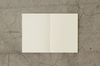 Thick cream notebook open to two blank pages with a central fold.
